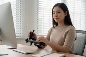 Asian woman using an adaptive device at a workspace on a cerebral palsy dating site